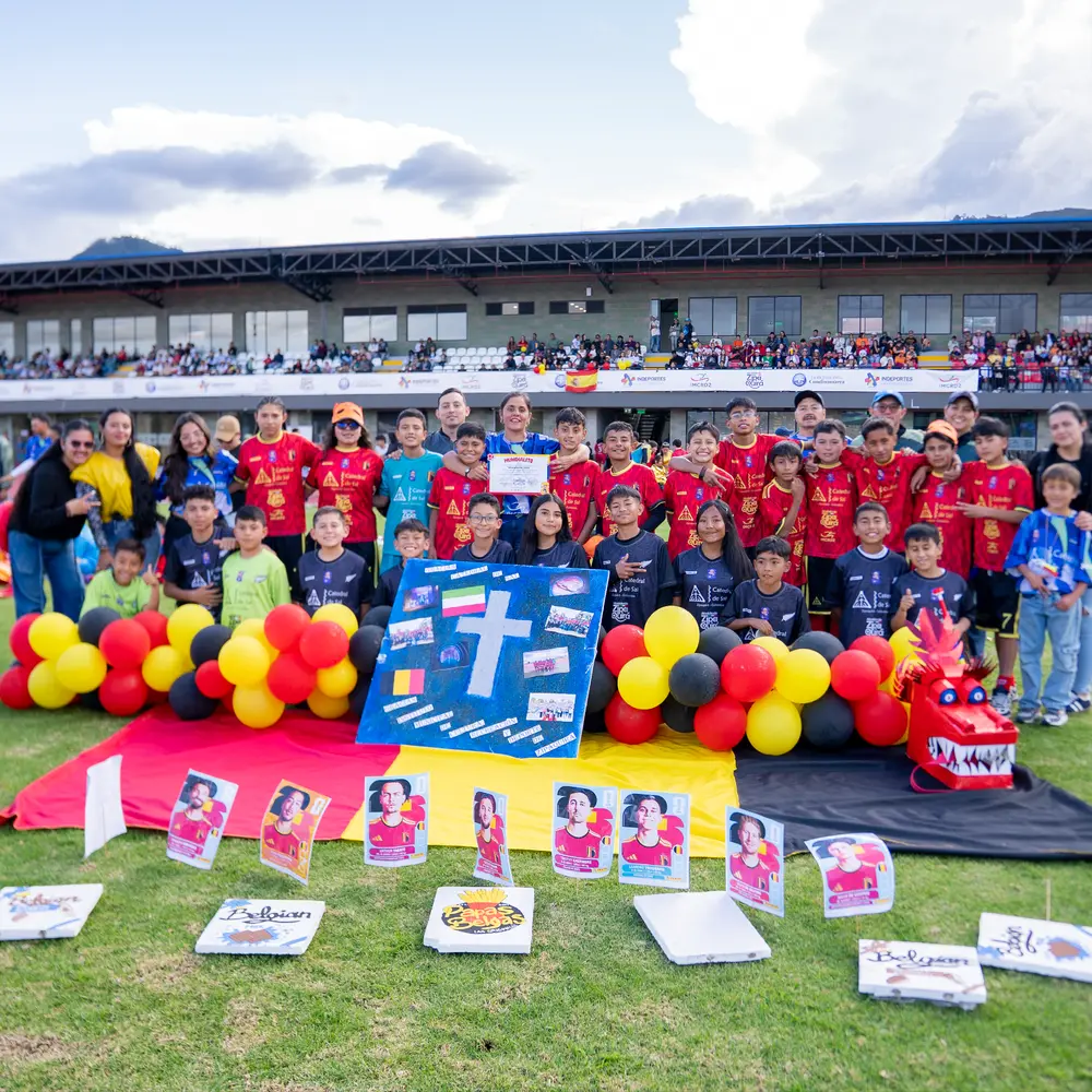 oto grupal de un equipo de fútbol infantil con uniformes del Mundialito 2026, globos decorativos y un cartel con una cruz en la Catedral de Sal.