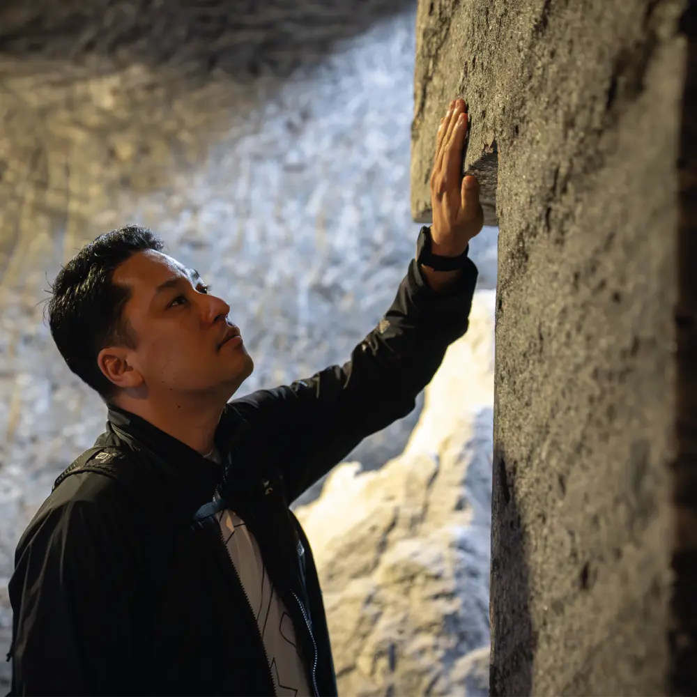 Un hombre contempla y toca una de las imponentes estructuras de roca tallada en el interior de la Catedral de Sal de Zipaquirá.