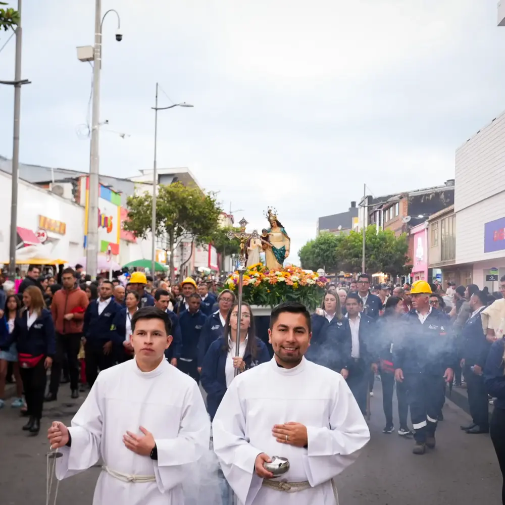 Acolitos encabezando con incienso la procesion multitudinaria de la Virgen del Rosario de Guasá acompañada por mineros y feligreses en las calles de Zipaquirá